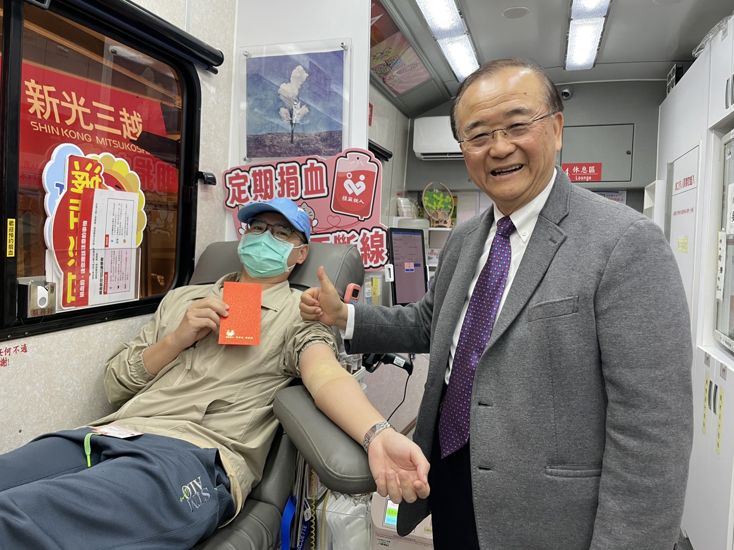台灣血液基金會董事長侯勝茂（右）向捐血人致贈紅包，獻上新年祝福